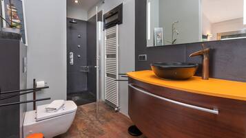 Een moderne badkamer met toilet, wastafel en douche.