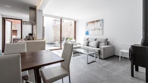 A modern living room with a sofa, coffee table, and dining table. - Vacation Home 'Casa Bugera' with Pool, Balcony, A/C & Wi-Fi (Pollenca)