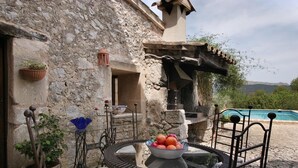 Un bâtiment en pierre doté d’une piscine, d’un espace extérieur aménagé et offrant une vue sur les montagnes.
