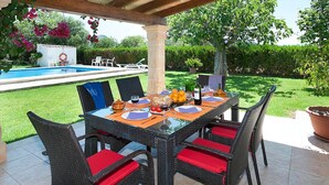 An outdoor dining area with a pool in the background. - Finca Villa Burgues with Mountain View, Pool, Garden, Terrace & Wi-Fi (Alcudia)