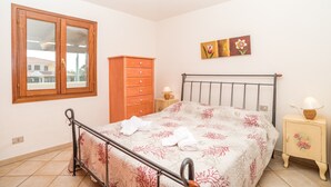 A bedroom with a bed, wooden wardrobe, and a window. - Holiday Home 'Trilocale con Ampia Veranda Mare' with A/C & Terrace (san teodoro)