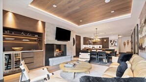 Una sala de estar moderna con chimenea, comedor y cocina.