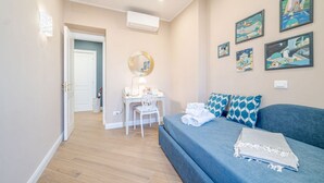 A bedroom with a bed, a desk, a chair, a wall-mounted mirror, and artwork. - GuestHost - Comfortable 40 sqm apartment perfect for 4 guests is located in the heart of the most authentic Genoese historic center, a few steps from Piazza delle Vigne and the church of the same name with the beautiful bell tower that stands out over th (Genova)