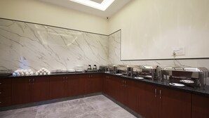 A modern kitchen with marble backsplash, stainless steel appliances, and a glass partition.