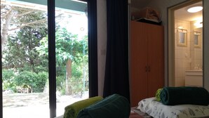 A room with a bed, a wardrobe, and a view of greenery outside. - Independent bedroom, swimming pool, Park, Kitchen, Barbecue... (Brézilhac)