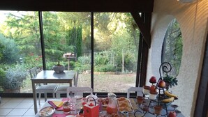 An outdoor dining area with a table set for breakfast, including croissants, fruit, and beverages. - Independent bedroom, swimming pool, Park, Kitchen, Barbecue... (Brézilhac)