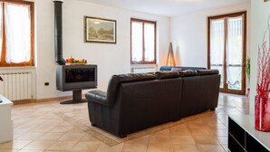 Ein Wohnzimmer mit einer Couch, einem Kamin und einem Bild an der Wand.