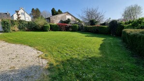 A well-maintained lawn with a gravel path leading to a house with a stone facade and a chimney. - QUIET STONE HOUSE 3KMS FROM THE BEACH (La Foret-Fouesnant)