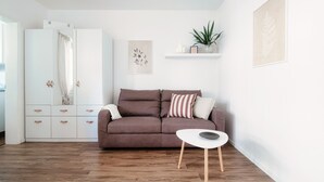 A modern living room with a brown sofa, a white coffee table, and a wooden floor. - Studio apartment a few steps from Piazza Grande and the lakefront (CITY 1) (Locarno)