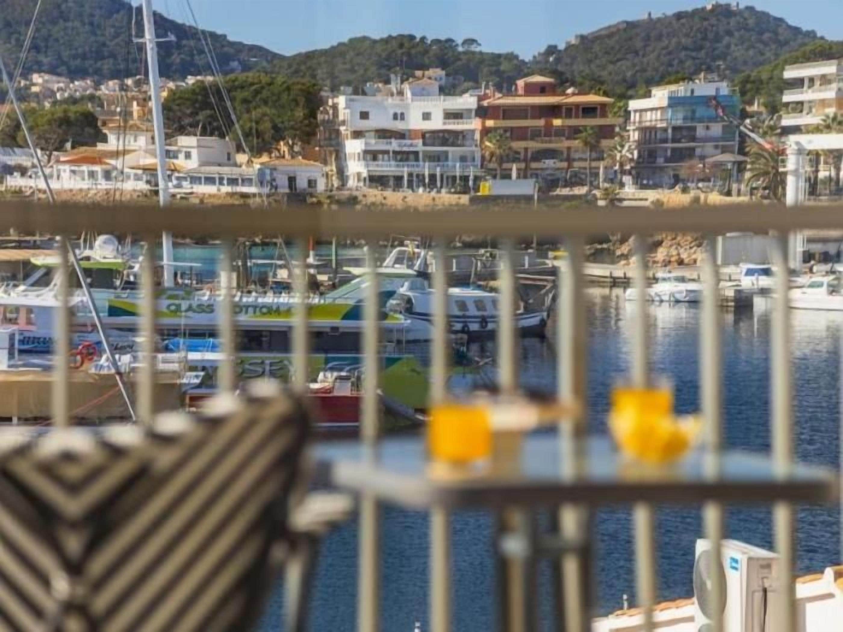 A marina with boats docked, a chair, and a table with yellow items.