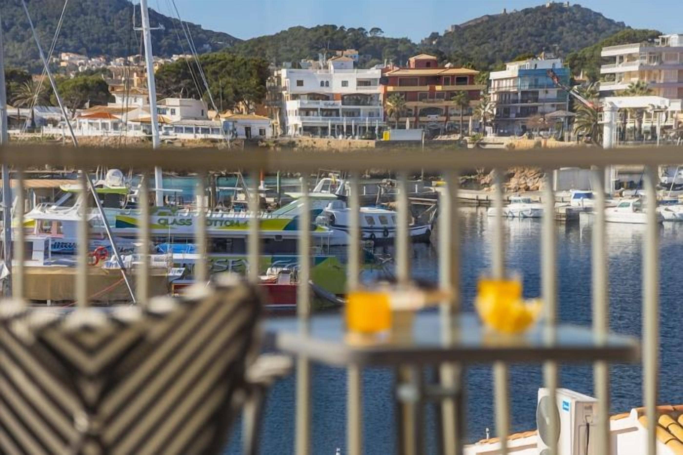 A marina with boats, a railing, and buildings in the background.