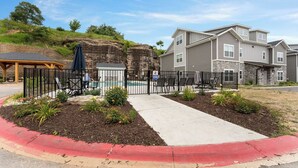 Zona residencial con piscina, patio cubierto y entrada protegida por un portón.