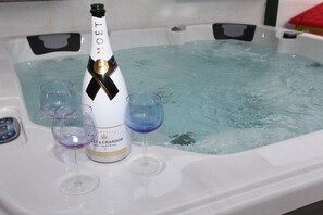 Ofurô com uma garrafa de Moët champagne e duas taças.
