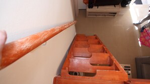 A staircase with wooden steps and a hand holding a wooden object. - Villa Ariadni Crete (Agios Vasileios)