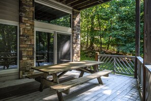 Enjoy outdoor dining or relaxation on this deck with a picnic table and views of the surrounding greenery.