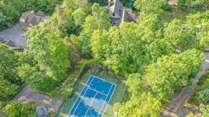 Enjoy tennis and relaxation in a serene, well-maintained outdoor setting surrounded by lush greenery and diverse architectural styles.