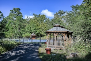 Escape to a serene oasis surrounded by lush greenery and a traditional gazebo.