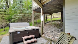 A hot tub with a wooden bench and a stone pathway. - Canadian Day by Taylor Made Deep Creek (McHenry)