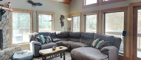 A cozy living room with a sectional sofa, a coffee table, and a fireplace.