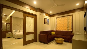 A modern living room with a sofa, a coffee table, and a bed with a nightstand. - Amritam Palace (Jodhpur)