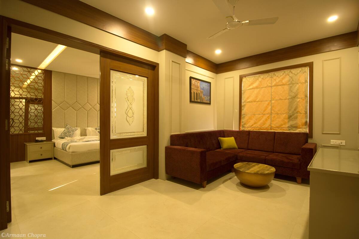 Uma sala de estar moderna com sofá, mesa de centro e cama com mesa de cabeceira.