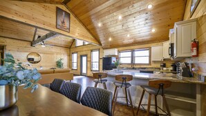 Un interno in legno con zona pranzo, cucina e posti a sedere al bancone.