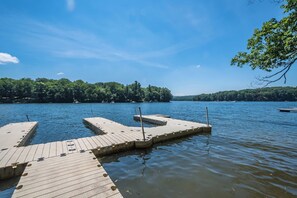Un moll de fusta que s'endinsa en un llac tranquil sota un cel serè.