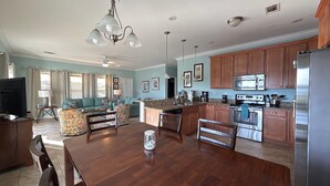 A spacious living area with a dining table, kitchen with modern appliances, and a cozy seating area.