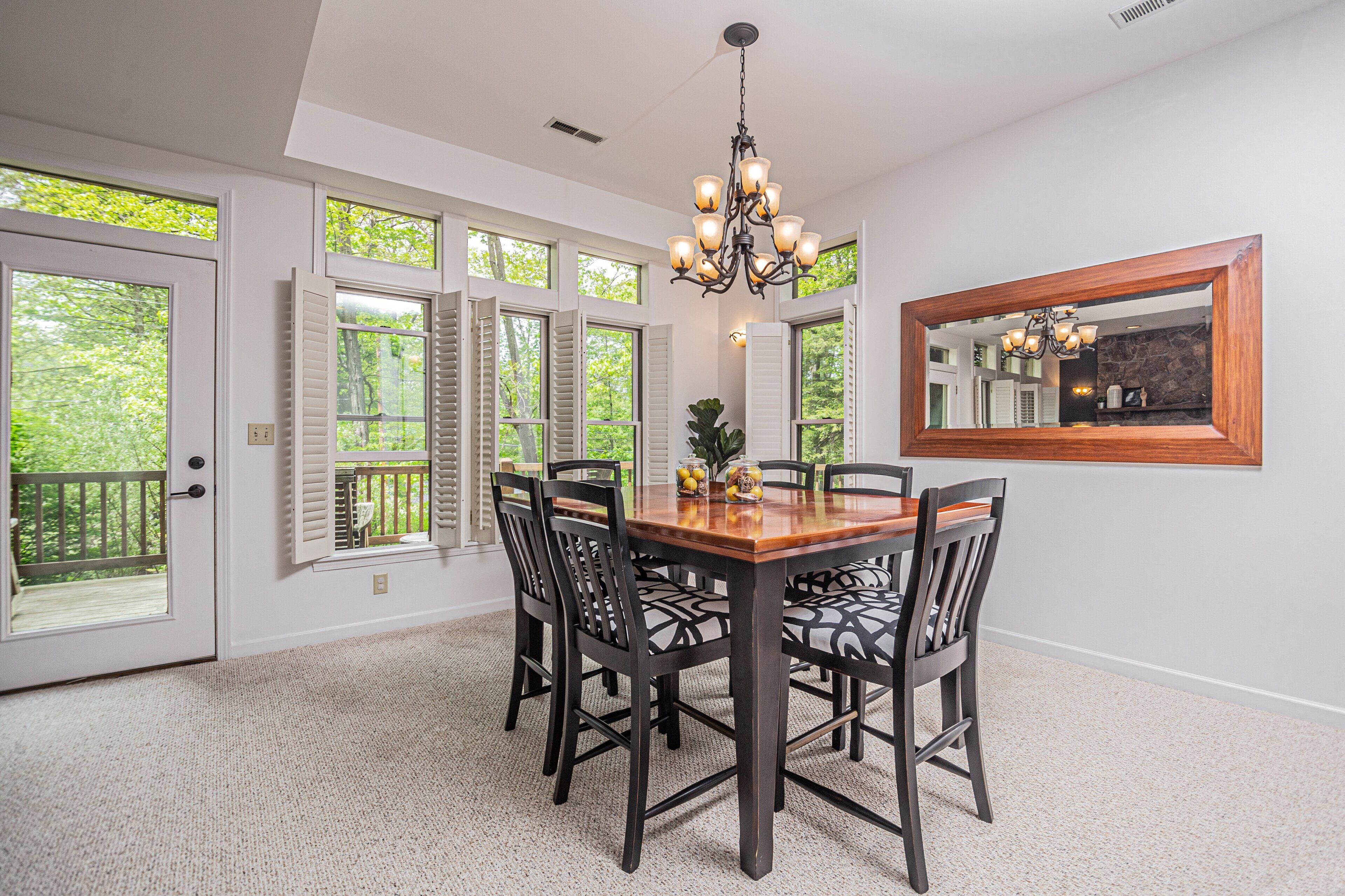 A dining area with a wooden table, black chairs, and a chandelier.