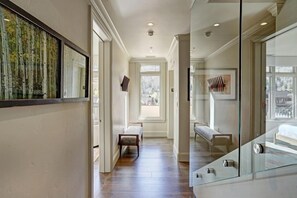 A hallway with a bench, a glass partition, and a large window with a view. - Luxury Mountain-Side Penthouse with Stunning Views! by RedAwning (Vail)