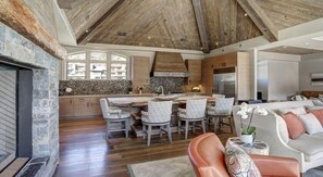 A spacious kitchen with a large island, wooden ceiling, and stone walls. - Luxury Mountain-Side Penthouse with Stunning Views! by RedAwning (Vail)
