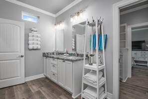 A bathroom with a double sink vanity, a large mirror, and a towel rack. - Soggy Bottom 3 Bedroom Home by RedAwning (Port Bolivar)