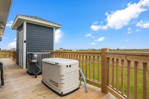 A deck with a Generac generator and a small shed. - Soggy Bottom 3 Bedroom Home by RedAwning (Port Bolivar)