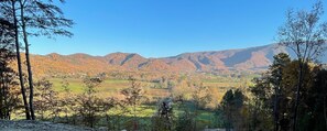 A mountainous landscape with autumn foliage, a valley with fields, and scattered trees. - Smoky Mtn Tiny Home+Hot Tub, Fire Pit & Views+2 miles to the Smokies (Sevierville)