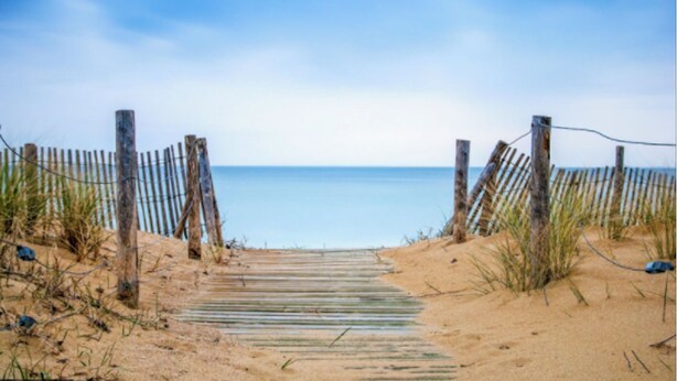 A sandy beach path leading to the sea, flanked by wooden fences and sparse vegetation. - VILLA LA COTINIERE (Saint-Pierre-d'Oléron)