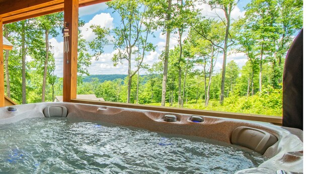 A hot tub with a view of a forest and mountains. - Cj's Mountain Lodge by Taylor Made Deep Creek (McHenry)