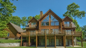 A large log cabin with a balcony and a stone foundation. - Colorado Dreamin' by Taylor Made Deep Creek (McHenry)