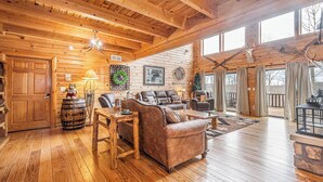 A spacious wooden cabin with a large living area featuring leather sofas, a wooden coffee table, and a fireplace. - Colorado Dreamin' by Taylor Made Deep Creek (McHenry)