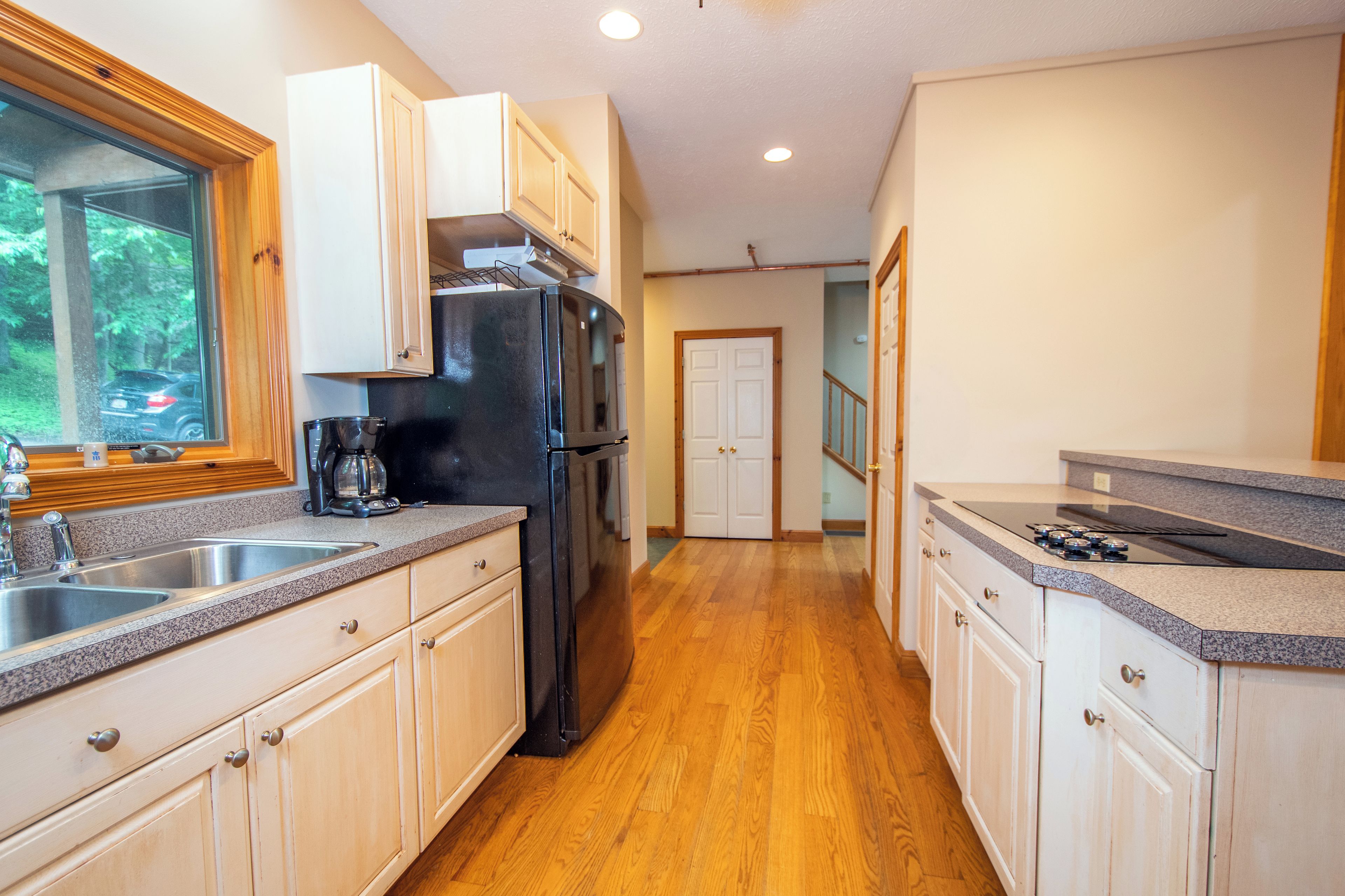 A kitchen with wooden cabinets, a stainless steel refrigerator, and a granite countertop.