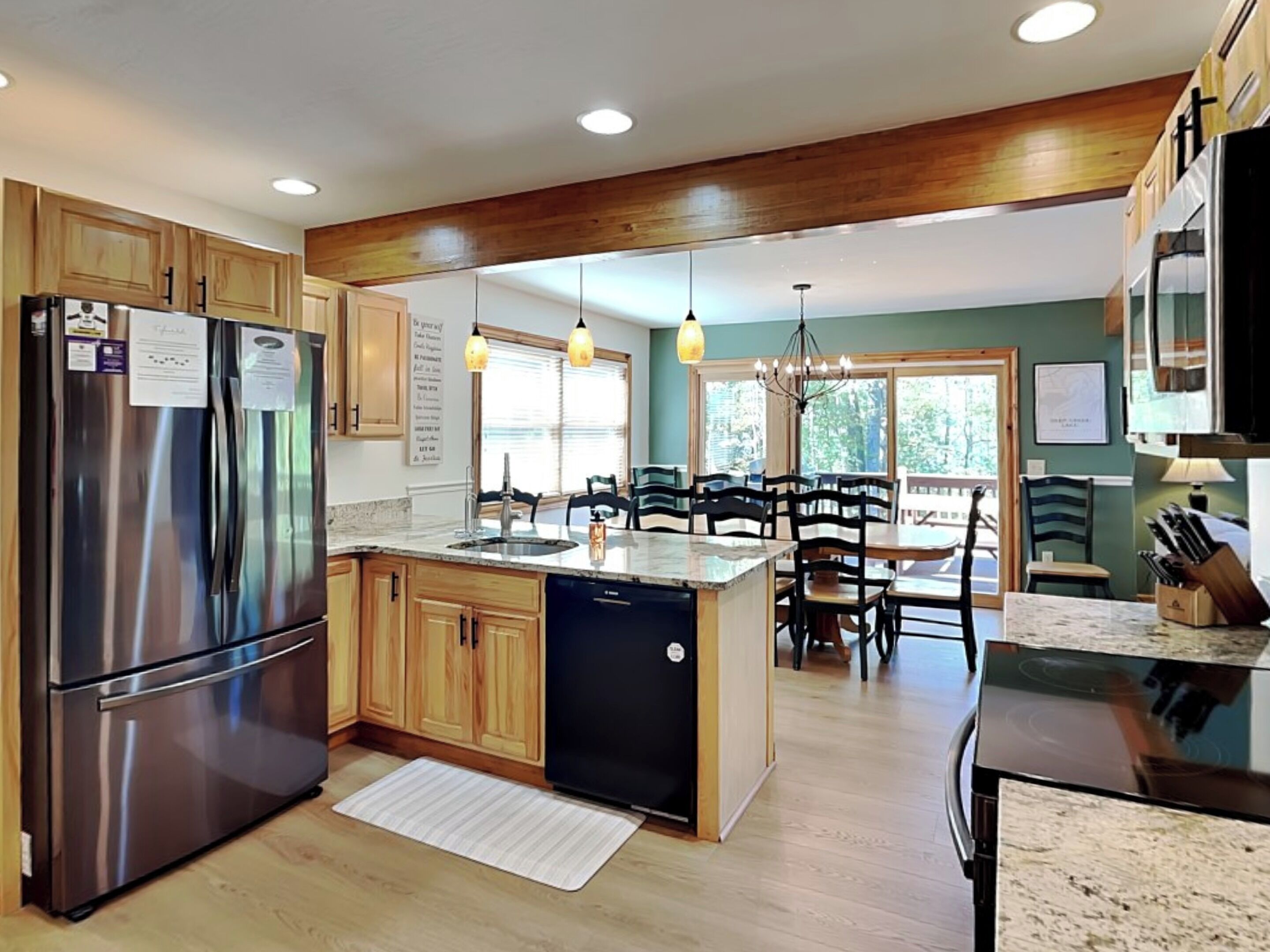 A modern kitchen with stainless steel appliances, wooden cabinets, and a central island.
