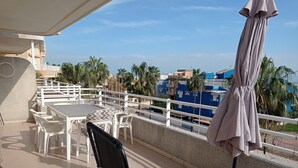 A balcony with outdoor seating, a table, and a chair. - Las Olas  4º Solo Familias! (Xeraco Playa)