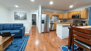 A modern kitchen with wooden cabinets, stainless steel appliances, and a tiled backsplash.