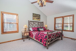 A bedroom with a bed, two nightstands, a ceiling fan, and two windows with blinds. - Dancing Bear Lodge by Taylor Made Deep Creek (McHenry)