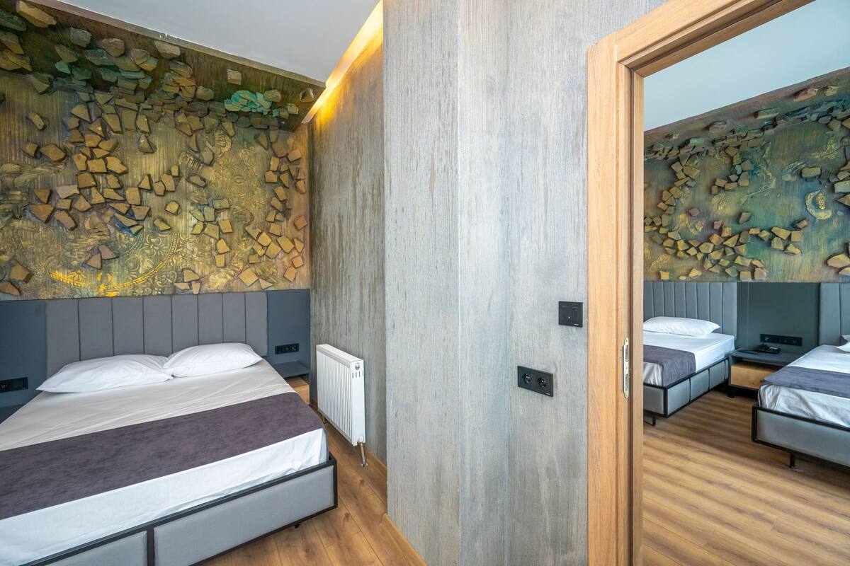 Un dormitorio moderno con una cama grande, una cama más pequeña y un armario con espejo.