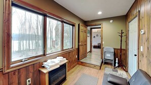 A cozy room with a fireplace, a couch, and a view through large windows. - Donnas Choice by Taylor Made Deep Creek (McHenry)