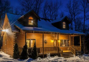 A log cabin with a porch, windows, and a snow-covered roof. - Donovan's Dacha by Taylor Made Deep Creek (McHenry)