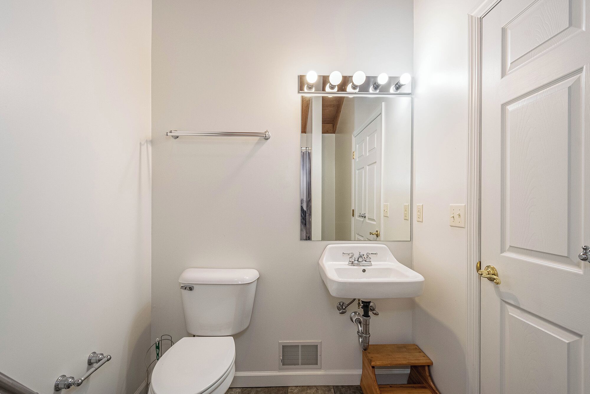 Un baño con inodoro, lavamanos, espejo y cortina de ducha.