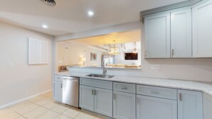 A modern kitchen with light grey cabinets, a stainless steel sink, and a dishwasher. - Two Bedroom Villa Steps from Robert Trent Jones Golf Course! (Hilton Head Island)