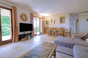A living room with a TV, sofa, dining table, and chairs. - Villa "La Couaste": Enjoy life in Provence. (Lorgues)