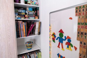 Zona de juegos infantiles con una pizarra, letras del alfabeto y juguetes de colores.